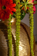 goudkleurige ronde vaas gevuld met bloemen